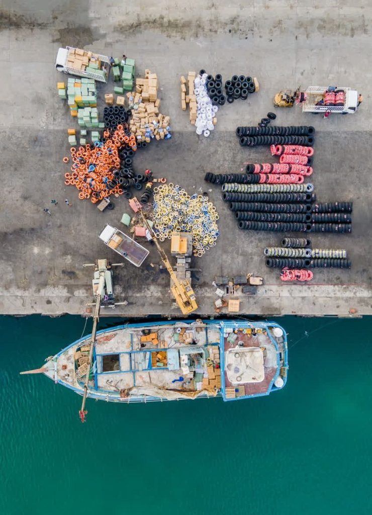 عکاس اصغر بشارتی-لنج پهلو گرفته کنار اسکله قشم از نمای بالا با بار تایر (لاستیک)